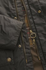 Close-up front view of Barbour Wax parka 'Bedale' dark olive showing durable waxed cotton, robust two-way zip with branded pull, press-stud storm flap, and signature tartan lining inside. An icon among wax jackets, the BARBOUR 'Bedale' returns this season