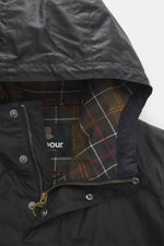 Nahaufnahme des Barbour Wachsparkas 'Bedale' navy von oben, zeigt Kapuze aus gewachster Baumwolle und typisches Tartan-Futter.