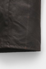 Barbour Wachsjacke 'Gamefair' dunkelgrün, Detailaufnahme der gewachsten Baumwolle mit Cordkragen, wasserabweisend, Regular Fit, Tartan-Futter, von vorne unten fotografiert.
