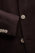 Nahaufnahme aus schräger Perspektive der dunkelbraunen Fedeli Cashmere Jersey-Jacke 'Garret' mit weichem Griff, Kissing Buttons und gestepptem Futter.