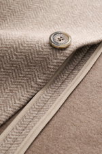 Nahaufnahme der braun gemusterten Fedeli Cashmere Jersey-Jacke 'Damon' mit Fischgrat-Muster und Knopf, Detail von Revers und Saum.