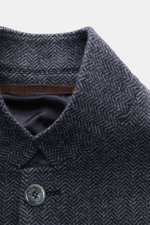 Nahaufnahme der variabel tragbaren Revers-Kragen der Fedeli Cashmere Jersey-Jacke 'Damon' grau gemustert mit Fischgrat und Knopf, von oben fotografiert.