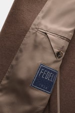 Close-up interior view of the Fedeli Cashmere Jersey Jacket 'Damon' brown showing soft cashmere fabric, unconstructed design, classic breast pocket, and branded button.