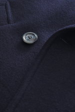 Nahaufnahme der Fedeli Cashmere Cabanjacke navy aus Doubleface-Jersey, Fokus auf Knopf, sehr weicher Griff, Slim Fit, variabler Kragen, zweireihiger Drei-Knopf-Stil, schräge Leistentaschen, Unconstructed Design, zwei Innentaschen, fotografiert aus Frontal