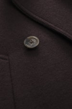 Nahaufnahme aus schräger Perspektive der Fedeli Cashmere Cabanjacke dunkelbraun mit Doubleface-Jersey, weichem Griff, Slim Fit, variablem Kragen, zweireihigem Drei-Knopf-Stil, schrägen Leistentaschen, Unconstructed Design und zwei Innentaschen.