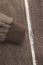 Nahaufnahme des Montecore Daunenblouson dunkelbraun/beige gemustert von vorne mit Details wie Mix aus Cashmere und Seide, softer Griff, Regular Fit, Zwei-Wege-Reißverschluss, Umlegekragen, schräge Leistentaschen, leichte Daunenfüllung, elastische Bündchen