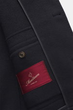 Close-up front view of the Montecore Cashmere Jacke navy showcasing pure cashmere fabric, slim fit, four-button double-breasted style, piped welt pockets, and a red Montecore label. Luxuriös durch Herbst und Winter: MONTECORE präsentiert dieses Modell aus