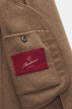 Close-up interior view of the Montecore Cashmere Jacket taupe melange showing the soft pure cashmere fabric, branded button, and red Montecore label.