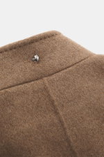 Close-up view of the stand-up collar with a silver dog head pin on the Montecore Cashmere Jacket taupe melange, made of pure cashmere with a soft touch.

<p>Luxurious through autumn and winter: MONTECORE presents this model made of pure cashmere as an ele