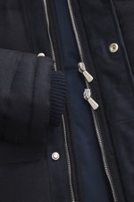 Close-up front view of the Mandelli Down jacket navy showing silver two-way zipper, snap fasteners, ribbed cuffs, and leather trim on navy wool-cashmere fabric. Luxurious wearing comfort for the cold season: The down jacket by MANDELLI made of virgin wool