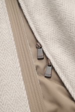 Close-up front view of the Colombo Jacket beige melange showing the two-way zipper with Colombo branding, featuring a mix of kid cashmere and kid wool, soft touch, slim fit, hood with drawstring, side seam pockets, smooth lining, and two inside pockets.