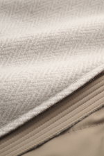 Close-up detail view of the fabric and zipper of the Colombo Jacket beige melange, made of a soft touch mix of kid cashmere and kid wool, showing the smooth lining and fine texture. The slim fit jacket features a two-way zipper, hood with drawstring, side