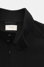 The Row Cashmere Blouson 'Olek' schwarz, Nahaufnahme von oben schräg, Stehkragen, weicher Kaschmirfilz, Knopfriegel, zwei-Wege-Reißverschluss, paspelierte Taschen.