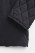 Nahaufnahme der Agnona Steppjacke navy von oben, Detail hochwertiger Microfaser, glatter Griff, Rippstrickbesatz am Umlegekragen, Regular Fit, Vier-Knopf-Stil, Fronttaschen, Brusttasche, Seitenschlitze, geschmeidiger Futterstoff, zwei Innentaschen.