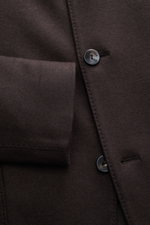 A close-up front view of the Agnona Jersey Jacket Dark Brown showcasing the soft wool-cashmere blend fabric, four-button style, adjustable lapel, patch hip pocket, and detailed stitching, highlighting its slim fit and unconstructed design. Finest craftsma