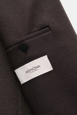 Close-up view of the dark brown Agnona Jersey Jacket showing the wool-cashmere fabric, patch pocket, black button, and white AGNONA label. Finest craftsmanship meets timeless elegance: This half-lined jersey jacket made from a wool-cashmere blend exemplif