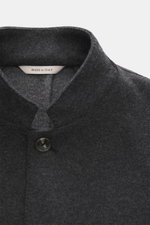 Agnona Jersey jacket dark grey melange shown from a close-up front top perspective, featuring a wool-cashmere blend, soft touch, slim fit, four-button style, variable lapel, patch hip pockets, rear side vents, unconstructed design, and two inside pockets.