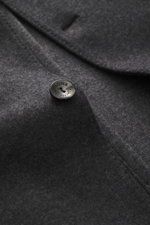 Close-up front angle of Agnona Jersey jacket dark grey melange showing four-button style, soft wool-cashmere fabric, and patch hip pocket.
