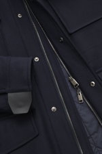 Close-up front view of the Brioni Cashmere jacket navy showing slightly elastic cashmere fabric, soft feel, lamb leather details, two-way zipper, snap buttons, and patch pockets.