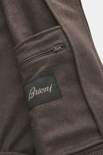 Nahaufnahme des Innenbereichs des Brioni Cashmere Blouson braun, fotografiert schräg von oben, mit Label, Reißverschluss und weichem Cashmere-Stoff.