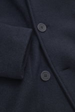 Close-up front view of the navy Lunaria Cashmere Cashmere Jacket featuring pure cashmere fabric, slim fit, notch collar, double-breasted three-button style with flap pockets, rear vents, unlined interior, and one inside pocket. Timeless elegance, masterfu