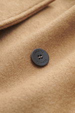 Close-up front detail of Lunaria Cashmere Cashmere Jacket beige showing soft pure cashmere fabric, black button with logo, and notch collar from a slightly angled top perspective. Timeless elegance, masterfully staged: The exclusive, lightweight jacket fr