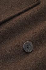 Close-up top view of the Lunaria Cashmere Cashmere Jacket Dark Brown showing soft pure cashmere fabric and a branded button, highlighting timeless elegance and slim fit design. Timeless elegance, masterfully staged: The exclusive, lightweight jacket from 