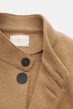 Nahaufnahme der Lunaria Cashmere Cashmere Jacke beige, slim fit, mit Reverskragen, Vier-Knopf-Stil und aufgesetzten Taschen, ungefüttert aus weichem, reinem Cashmere, fotografiert von oben leicht schräg.