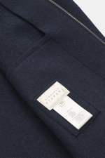 Close-up top-down view of Lunaria Cashmere Cashmere Blouson navy showing pure cashmere fabric, very soft touch, slim fit, two-way zipper, stand-up collar, slanted front pockets, elastic hem and sleeve cuffs, and unlined interior.