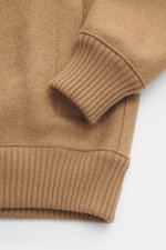 Close-up angled view of the Lunaria Cashmere Cashmere Blouson beige showing ribbed elastic hem and sleeve cuffs, pure cashmere, very soft touch, slim fit, two-way zipper, stand-up collar, slanted front pockets, unlined.