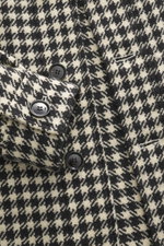 Nahaufnahme der Ami Paris Wolljacke schwarz/creme kariert mit Hahnentritt-Webmuster, Fünf-Knopf-Leiste und Manschetten, Mix aus Schurwolle und Microfaser, griffige Qualität, Regular Fit, Umlegekragen, Taschen in der Seitennaht, Rückenpasse mit Schlaufe, L