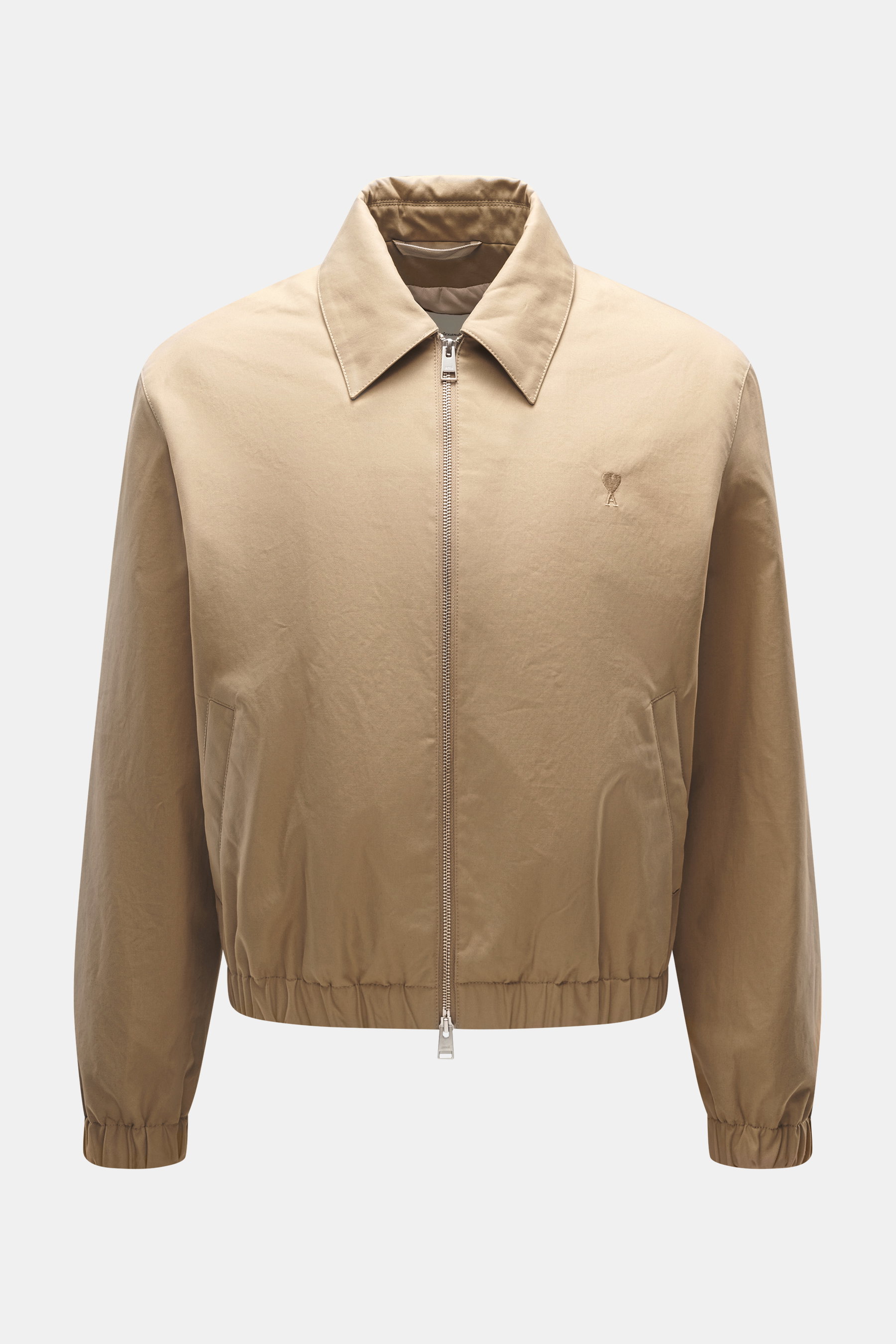 Front view of Ami Paris Beige Blouson made of twill cotton with soft touch, unisex regular fit, robust two-way zipper, turn-down collar, slanted front pockets with snap button, tonal logo stitching on the chest, elastic hem finishes, soft twill lining, an