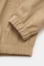 Nahaufnahme des elastischen Saumabschlusses und Ärmels des Ami Paris Blouson beige, Twill Baumwolle, Regular Fit, Unisex-Modell, mit weichem Griff.