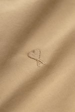 Ami Paris Blouson beige aus weichem Baumwoll-Twill, Unisex, Regular Fit, Frontansicht mit robustem Zwei-Wege-Reißverschluss, Umlegekragen, Druckknopf-Taschen, tonalem Logo-Stitching, elastischen Saumabschlüssen, softem Twill-Futter und zwei Innentaschen.