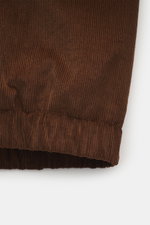 Nahaufnahme des braunen Ami Paris Cord-Blouson aus Baumwolle, weicher Griff, elastischer Saum, Detail von twillgefüttertem Unisex Regular Fit.