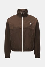 Vorderansicht des Ami Paris Blouson 'Windbreaker' braun aus hochwertiger Microfaser mit glattem Griff, Regular Fit, robustem Reißverschluss, im Kragen versteckter Kapuze, paspelierten Fronttaschen mit Knopf, Logo-Detail auf der Brust, elastischen Saum- un
