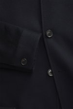 Nahaufnahme der Zegna Cashmere Jacke navy mit weichem Griff, Slim Fit, Vier-Knopf-Leiste, Stehkragen und Knopfriegel, fotografiert von vorne.