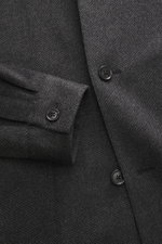 Close-up front detail of Zegna Cashmere jacket dark grey/black checkered, photographed from above, showing pure cashmere, soft touch, slim fit, four-button placket, turn-down collar, patch front pockets, sleeve cuffs with buttons, rear side vents, half li