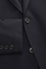 Nahaufnahme eines Zegna Cashmere Sakkos navy, fotografiert aus frontaler Perspektive, zeigt taillierten Zwei-Knopf-Stil mit weichem, reinem Cashmere und aufgesetzter Hüfttasche.
