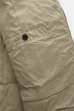 Nahaufnahme der Massimo Osti Studio Daunenjacke taupe, Detailansicht von Tasche mit Knopf, hochwertiger Microfaser, weicher Griff, matte Optik.