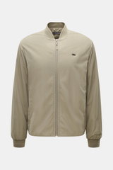 Massimo Osti Studio Jacke taupe, frontal fotografiert, Slim Fit, hochwertige Microfaser, weicher Griff, matte Optik, PrimaLoft® Wattierung, Blousonkragen, Seitentaschen, Metall-Logo, gerippte Bündchen, Innentasche, tonales Logo-Stitching, regulierbarer Sa