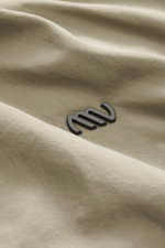 Nahaufnahme der Massimo Osti Studio Jacke taupe aus hochwertiger Microfaser mit weichem Griff, matter Optik und kleinem Metall-Logo.