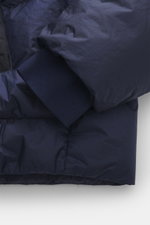 Close-up detail of the elastic rib cuff and sleeve of the C.P. Company Down jacket dark blue, photographed from above, showing high-quality ripstop microfiber with a lightly textured feel. This slim fit jacket features wind- and water-repellent fabric, wa