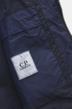 C.P. Company Down jacket dark blue shown close-up from the front, featuring high-quality ripstop microfiber, lightly textured feel, wind- and water-repellent fabric, warm down filling, garment dyed look, slim fit, robust two-way zipper, practical hood, fr