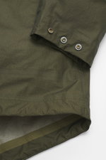 Nahaufnahme der Ärmelmanschette der C.P. Company Daunenjacke oliv aus Ripstop Microfaser mit glattem Griff, windabweisend, wasserdicht, Regular Fit.