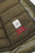 Nahaufnahme der Innenseite der C.P. Company Daunenjacke oliv aus Ripstop Microfaser, mit Label, Tasche und Reißverschluss, Detail von oben.