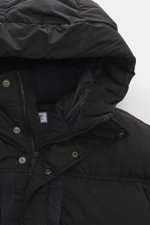 Close-up top-front view of C.P. Company Down jacket 'Nycra-R' black, featuring high-quality recycled microfiber, lightweight elastic fabric, water-repellent, warm down filling, garment dyed, slim fit, two-way zipper, wind flap with press studs, hood with 