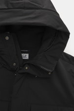 Close-up front view of the C.P. Company Parka 'Long Jacket' schwarz hood and collar, showing wind- and water-repellent microfiber, soft grip, durable zipper, snap button wind flap, hidden hood, and smooth lining.