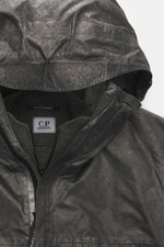 Close-up front top view of C.P. Company Jacket 'Metropolis' dark grey, made of high-quality microfiber with smooth feel, wind- and water-repellent fabric, warm wool inlay, slim fit, durable zipper, high-closing collar, hood with drawstring, zipper hand wa