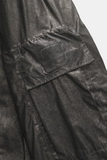 Close-up side view of C.P. Company Jacket 'Metropolis' dark grey showing logo detail on arm pocket, high-quality microfiber, smooth feel.
